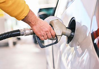 Jemand hält den Zapfhahn in sein Fahrzeug und tankt